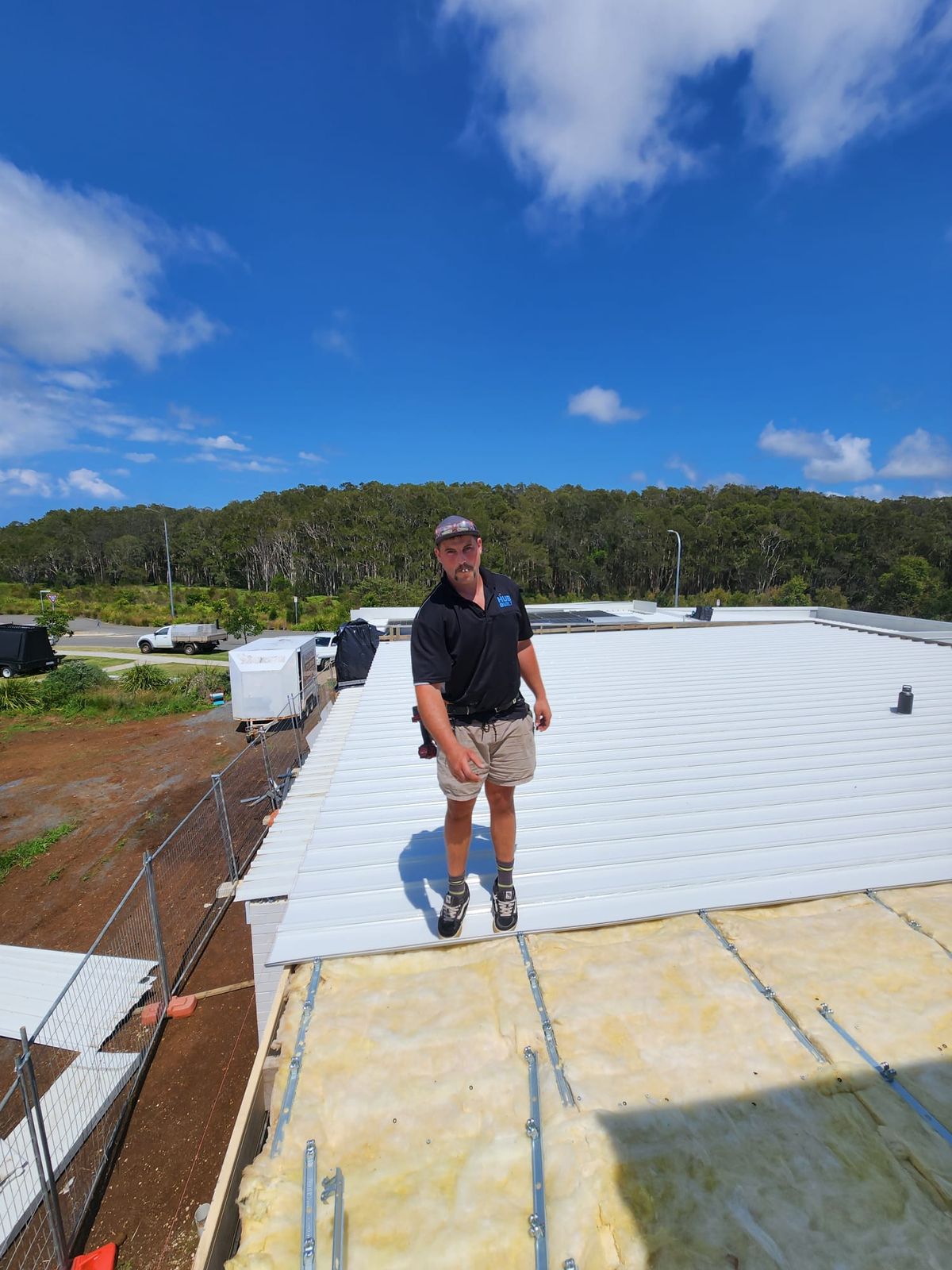Worker on new metal sheeting laid over insulation