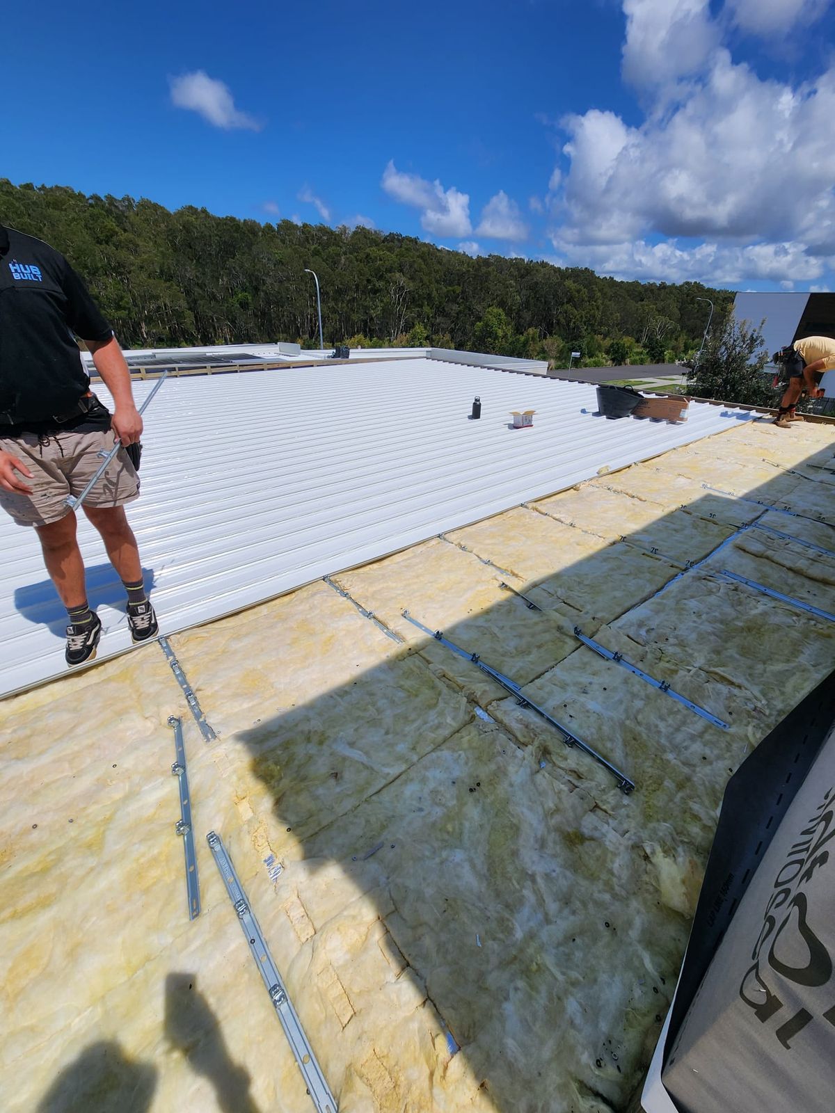 Worker laying metal sheeting beside the insulation blanket